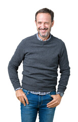 Handsome middle age senior man wearing a sweater over isolated background winking looking at the camera with sexy expression, cheerful and happy face.