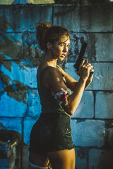 A Woman Holding a Gun in Front of a Wall