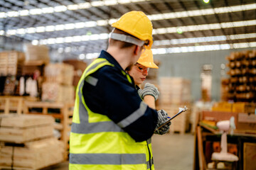 workers man and woman engineering walking and inspecting timbers wood in warehouse. Concept of smart industry worker operating. Wood factories produce wood palate.