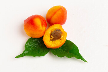 Sweet bright apricots with leaves on a white background