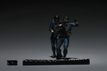 Selective focus picture of miniature anti terrorist soldier with miniature keyboard insight.