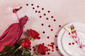 Festive table place setting for Valentines Day with bottle of wine and red roses. Romantic Valentines dining concept. Invitation for a date. Top view, flat lay
