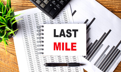 LAST MILE text on a notebook with chart and calculator