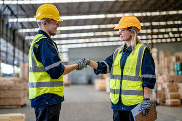 workers man and woman engineering walking and handshakeing with working suite dress at warehouse....