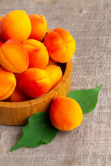 Apricots with leaves on  old wooden table