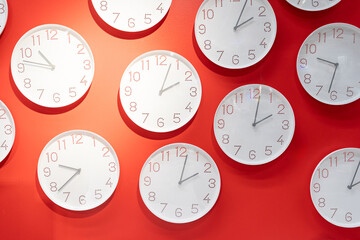 Many clock on red wall. clock concept. Time management concept with many clocks. 