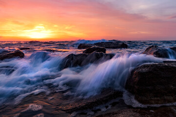 Splash of seawater in the morning on the shore of the Black Sea. Beautiful motion blur sea waves over the rocks.