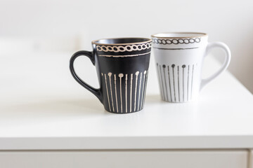 Two porcelain grey cups are on the white table.