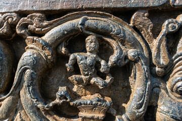 Beautiful intricate patterns and carvings of figurines on the wall of the ancient Chennakeshava temple in Belur, Karnataka.