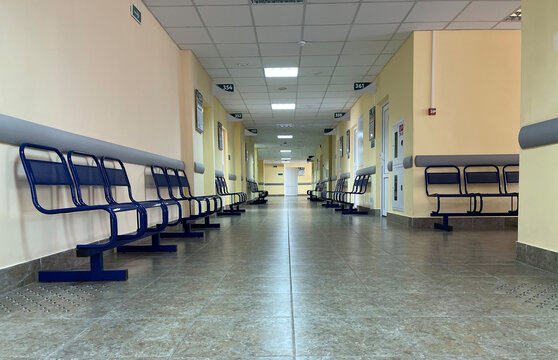 A view of an empty hospital corridor with visitor's chairs.