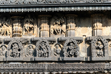 Fototapeta premium Beautiful intricate patterns and carvings of figurines on the wall of the ancient Chennakeshava temple in Belur, Karnataka.