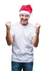 Middle age hoary senior man wearing christmas hat over isolated background celebrating surprised and amazed for success with arms raised and open eyes. Winner concept.