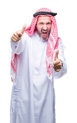 Senior arab man wearing keffiyeh over isolated background approving doing positive gesture with hand, thumbs up smiling and happy for success. Looking at the camera, winner gesture.