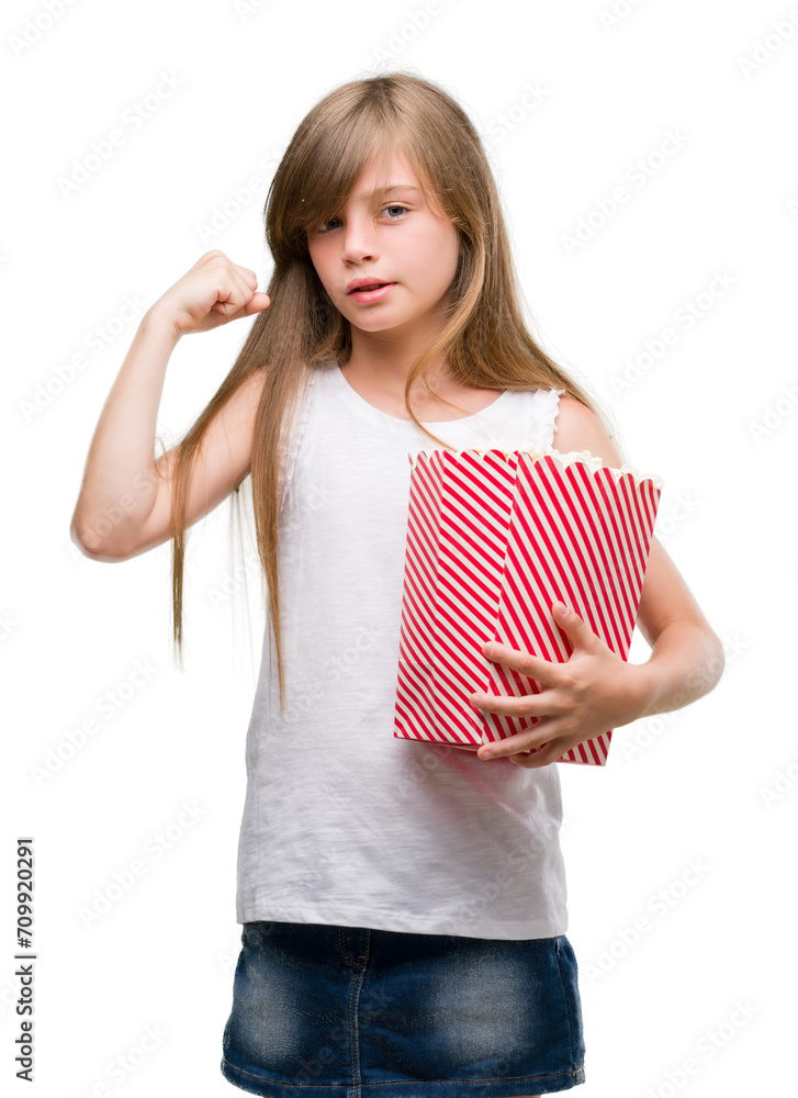 Wall mural young blonde toddler holding popcorn pack annoyed and frustrated shouting with anger, crazy and yell