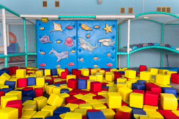 Playground with soft colorful blocks and a blue climbing wall.