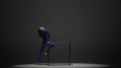 Portrait of female acrobat isolated on black background. Woman gymnastic dancer in blue sparkling...