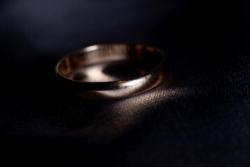 Wedding golden ring closeup on dark background. Luxury jewellery