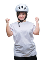 Young adult cyclist woman with down syndrome wearing safety helmet over isolated background very happy and excited doing winner gesture with arms raised, smiling and screaming for success