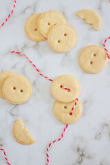 Button shaped handmade cookies on white background. Flat lay, top view.