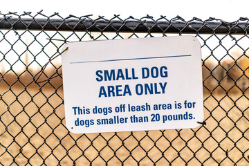 dogwalking: small dog area only dogpark signage on chainlink fence with blurred background this...