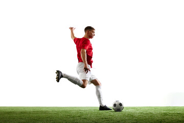 Obraz premium Triumphant kick towards victory. Professional football player sends ball into goal against white background. Concept of sport games, hobby, energy, world cup season, match, movement. Ad