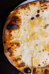 Pizza tradizionale napoletana ai quattro formaggi servita in una pizzeria