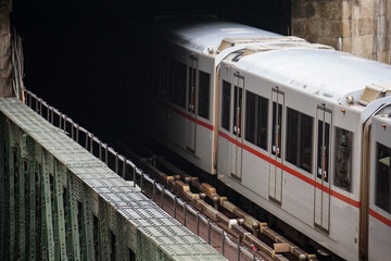 City train crossing steel bridge into dark tunnel ominous cinematic