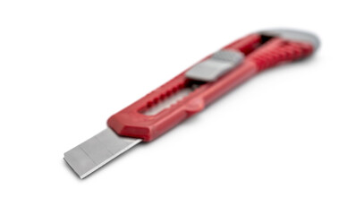Red stationery knife on a white background. - 709954845