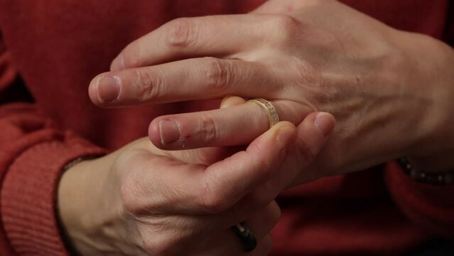 gros plan sur une femme enlevant son alliance de sa main