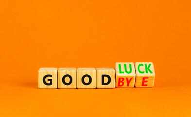 Good luck or goodbye symbol. Concept words Good luck or Goodbye on beautiful wooden blocks. Beautiful orange table orange background. Business, motivational good luck concept. Copy space.