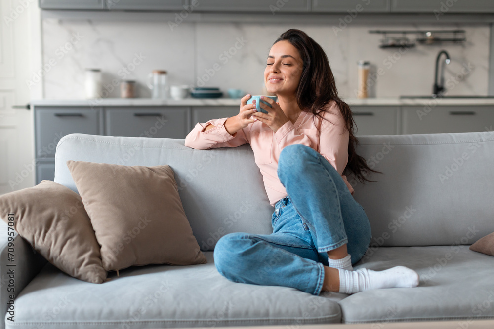 Sticker content woman savoring coffee on comfortable couch - Stickers