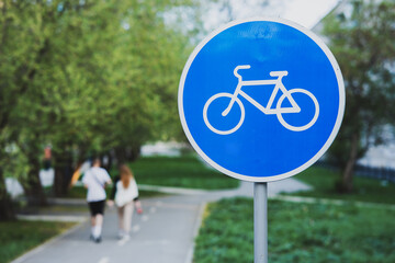 a blue circular bicycle sign at the bike path