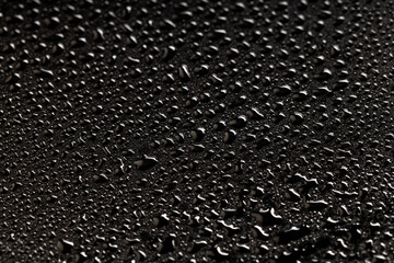 solid background of water droplets on a black plastic background