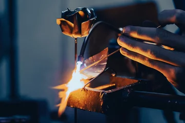 Foto op Canvas A craftsman welding a metal rose © ZenitX