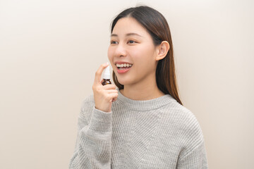 Health care treatment sore throat concept, sick pain asian young woman have cough symptom holding medicine bottle, using spray in mouth to protect disease from bacteria, illness from virus infection.