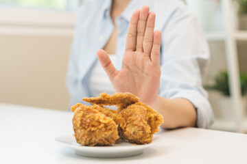 Diet, Dieting concept young woman hand push out, reject fried chicken on plate, deny to eat fast,...