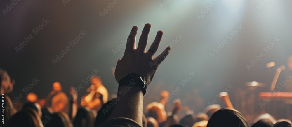 Wall mural raised hand at christian music concert.