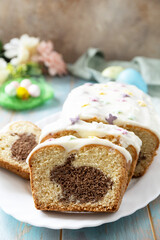 Cupcake with Easter Bunny and colorful eggs on a wooden blue tabletop. Copy space.