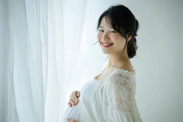 Fototapeta premium 白いドレスを着た日本人女性のマタニティフォト（妊娠・出産・記念） 