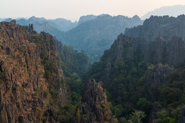 Obraz premium Silhouettes of limestone rocky hills at sunset. Laos