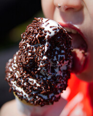A child enjoys a tasty soft serve ice cream cone covered in chocolate sprinkles.