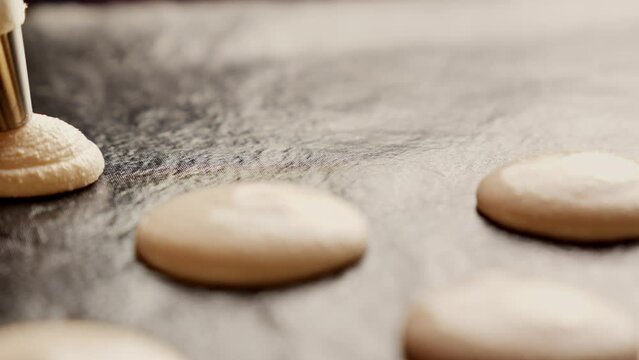 Chef making macaron dessert. Extruding macaroons on baking tray. Baking concept. Macaron dessert. Making French dessert. Close-up in 4K, UHD