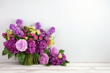 Bouquet of purple and pink flowers on a wooden table against a white wall . Springtime Concept. Mothers Day Concept with a Copy Space. Valentine's Day with a Copy Space.	