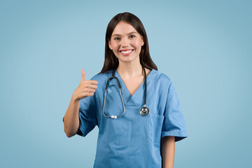 Smiling nurse in blue with stethoscope giving thumbs up, blue background