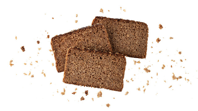 Cutting slices of dark rye cereal bread with crumbs flying isolated on white background.