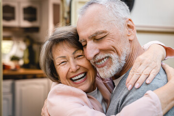 Cheerful caucasian senior old elderly couple spouses husband and wife hugging bonding embracing with love and care traveling by camper van trailer motor home
