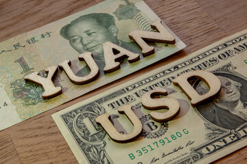 American dollar currency and Chinese yuan cross exchange rate theme, usd and yuan renminbi word concept made of wooden letters on wooden background