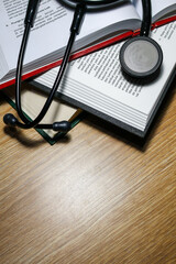 A black stethoscope on medical student textbooks for doctor. A medical education learning concept.