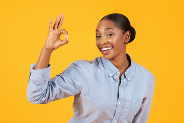 Cheerful Black Lady In Casual Gesturing Okay Symbol, Yellow Background