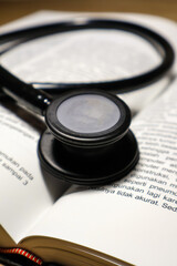 A black stethoscope on medical student textbooks for doctor. A medical education learning concept.